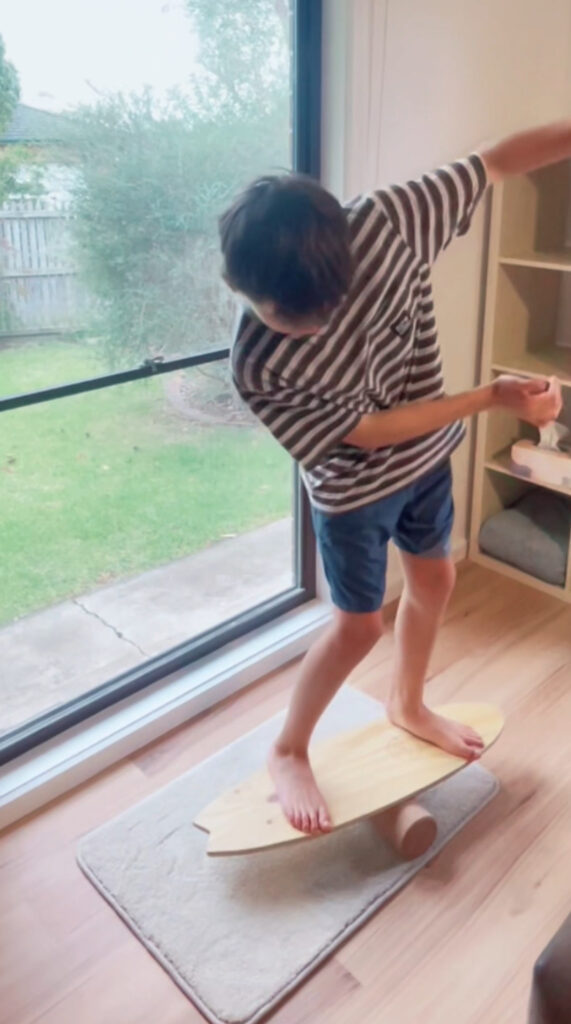 Family using surf balance board at home, practicing balance exercises
