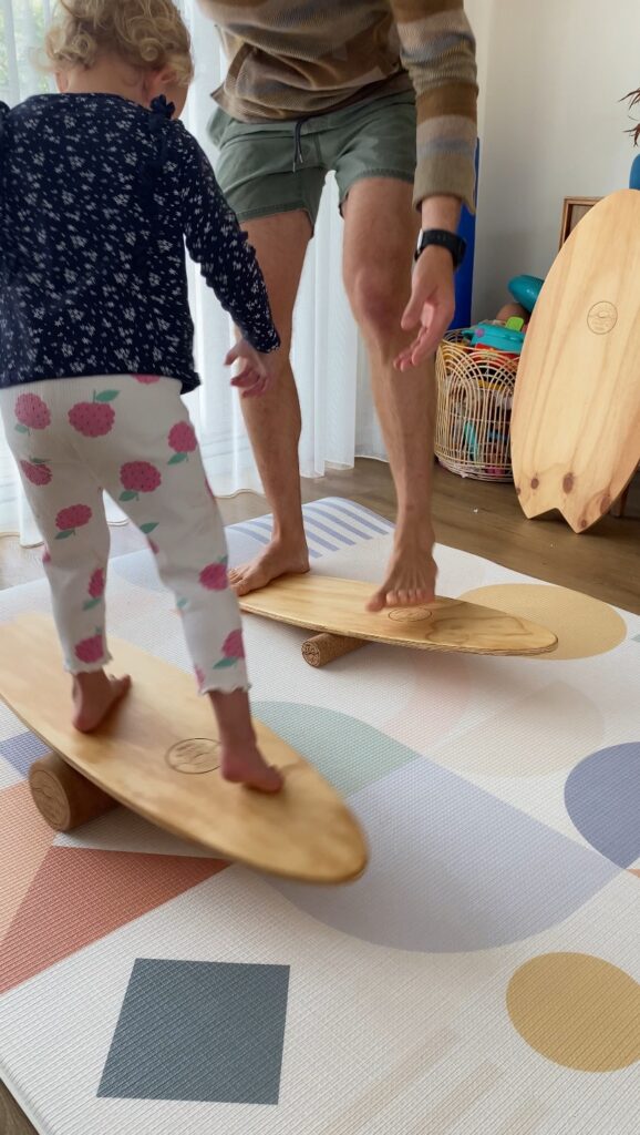 parent and child doing balance board training at home